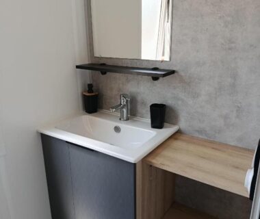 Coin lavabo avec miroir et étagère dans le mobil-home Superbe mobil-home à Seignosse plage