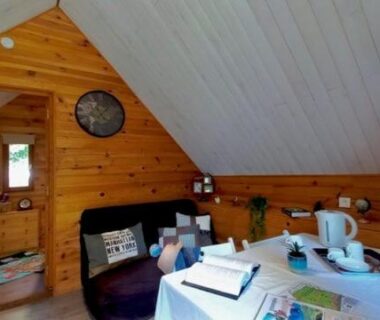 Intérieur mansardé avec table et canapé au TRAPPEUR - Les Chalets du lac Belcaire