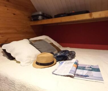 Chambre mansardée avec lit, chapeau et magazine dans le TRAPPEUR - Les Chalets du lac Belcaire