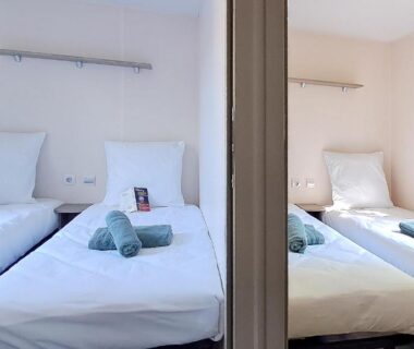 Chambre avec deux lits et serviettes dans l'hébergement Temps Suspendu