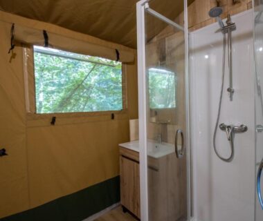 Salle d'eau avec douche et lavabo dans la Tente Lodge 8 personnes