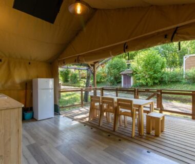 Terrasse couverte avec table et kitchenette dans la Tente Lodge 8 personnes