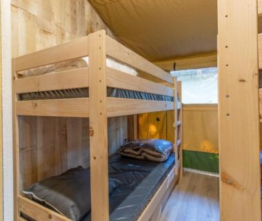 Intérieur avec lits superposés en bois dans la Tente Lodge 8 personnes
