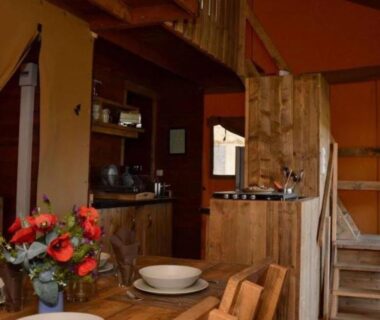 Intérieur avec coin repas, fleurs et kitchenette dans la Tente Lodge pour 8 avec Terrasse à Sartène API-1-52-1656