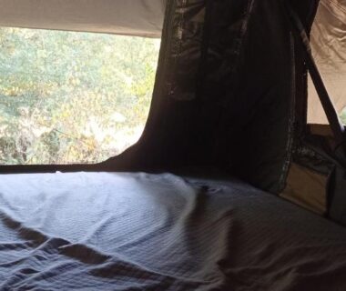 Intérieur de tente avec lit et fenêtre dans la Tente Perchée Kenya MAS DE BOUZOU