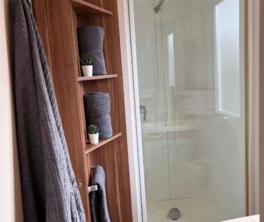 Salle de bain avec cabine de douche et serviettes dans le mobil-home Terra Cosy