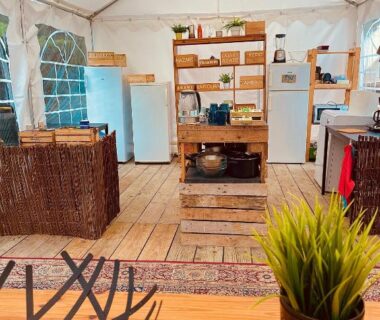 Intérieur de tente avec kitchenette et mobilier en osier dans The Spot – 200m de la Plage