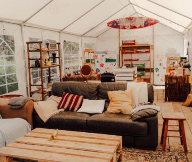 Salon sous tente avec canapés et table basse au camping The Spot - 200m de la Plage