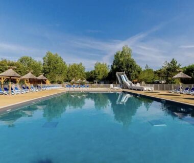 Piscine extérieure avec toboggan et transats au camping The Spot 200m de la Plage