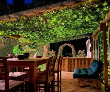 Terrasse éclairée sous pergola avec table à manger dans le Tiki House M-Home-Climatisé - Belle parcelle