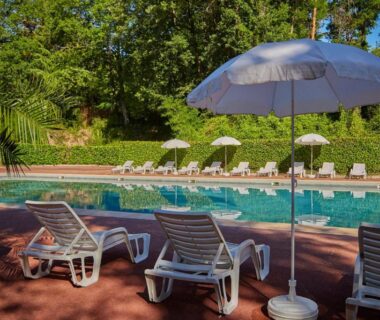 Bord de piscine avec transats et parasol au Tiki House M-Home Climatisé