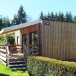 Mobilhome en bois sur la pelouse avec terrasse au Camping Les Granges Bas