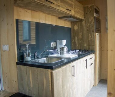 Coin cuisine équipé en bois dans la tiny house du Camping Les Granges Bas