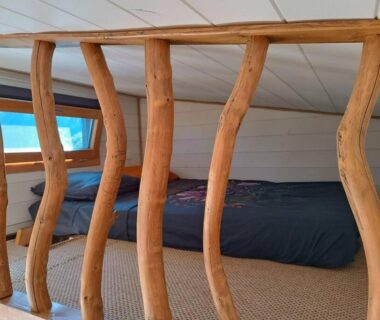 Mezzanine avec lit et balustrade en branches dans la Tiny House de la Côte Roannaise