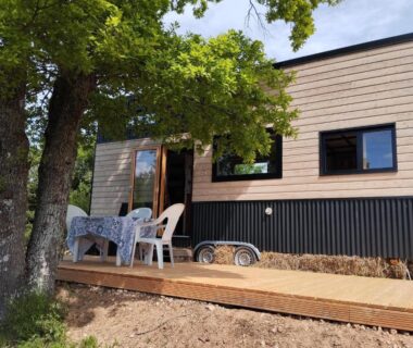 Terrasse en bois sous arbre avec table et chaises à la Tiny House de la Côte Roannaise