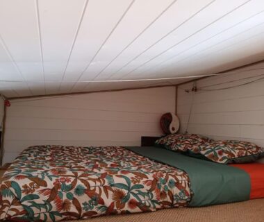 Intérieur mansardé avec lits et couettes dans la Tiny House de la Côte Roannaise