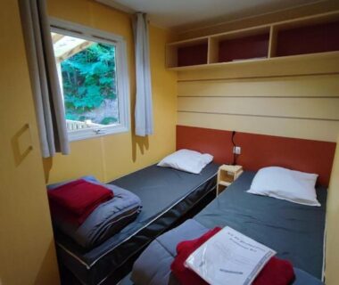 Intérieur avec deux lits simples et serviettes dans le Tiny Sweet Home