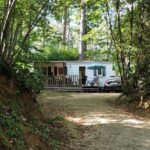 Chemin forestier menant à un mobil-home sur terrasse au Tiny Sweet Home 3 nuits minimum
