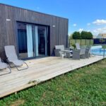 Terrasse en bois avec transats et piscine du Tiny house – piscine et vélos