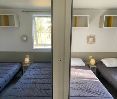 Chambre avec deux lits, lampes et fenêtre au Tohapi camping Atlantic Club