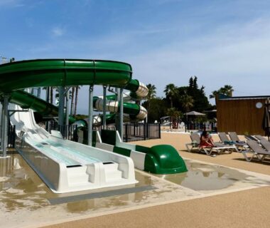 Aire aquatique avec toboggans et chaises longues au camping Tribord Dix Neuf