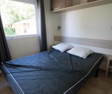 Chambre avec lit et fenêtre dans le mobil-home Ty Névez