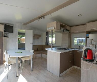 Intérieur avec kitchenette et coin repas dans le mobil-home Ty Névez