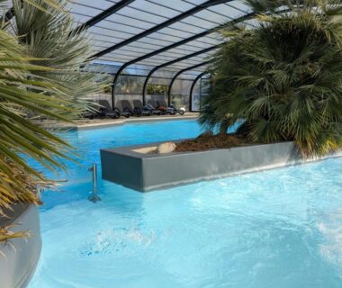 Piscine couverte avec palmiers au camping Ty Névez