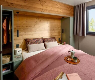 Chambre avec lit double et mur en bois au camping U Pinarellu