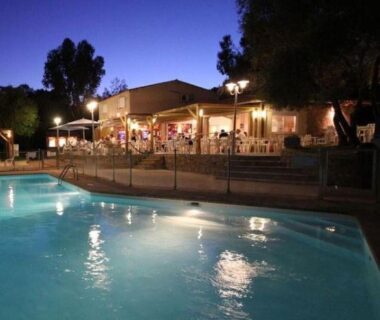 Piscine éclairée avec terrasse et tables du camping U Pinarellu