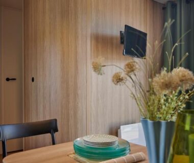 Coin repas intérieur avec table vaisselle et télévision dans le camping U Pinarellu