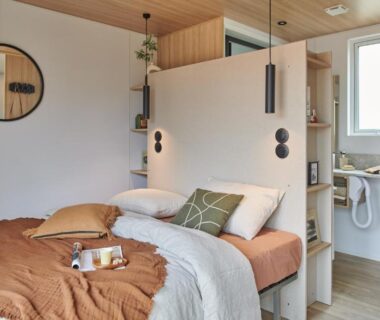 Intérieur de mobil-home avec lit coin lavabo et miroir dans le camping U Pinarellu