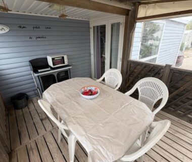 Terrasse couverte avec table et chaises dans le camping Un coin de paradis à Palavas les Flots