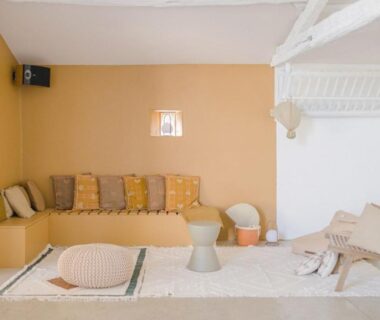 Coin salon lumineux avec banquette et coussins dans l'hébergement Un éco-camping en Vendée