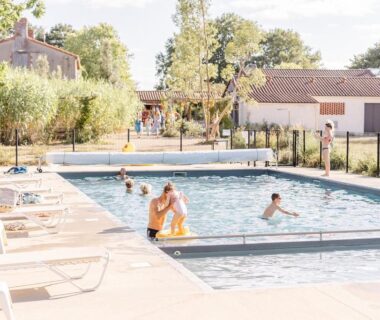 Piscine extérieure avec baigneurs et transats dans Un éco-camping en Vendée