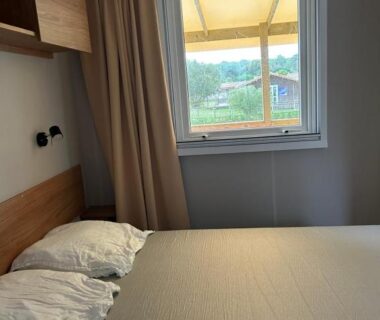 Chambre double avec lit et fenêtre donnant sur le jardin dans Un été au Cap Ferret