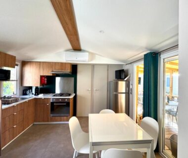 Intérieur avec cuisine ouverte et coin repas dans le mobil-home Un toit sur le bassin Claouey