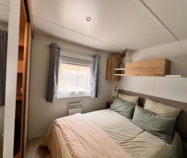 Chambre avec lit double et fenêtre dans le bungalow Un toit sur le bassin