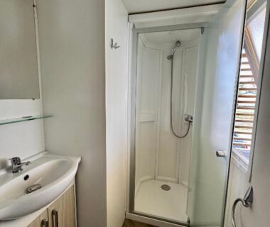 Salle de bain avec cabine de douche dans le bungalow Un toit sur le bassin au camping les viviers