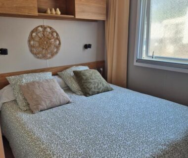 Chambre avec lit double, coussins et fenêtre dans l'hébergement Un toit sur le bassin les Embruns