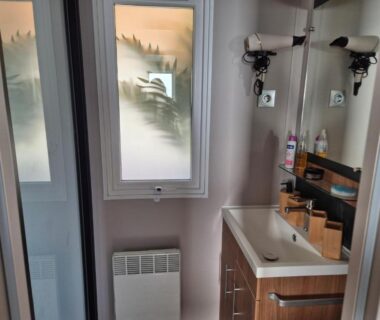 Salle de bain avec lavabo et miroir et fenêtre dépoli dans Un toit sur le bassin les Embruns