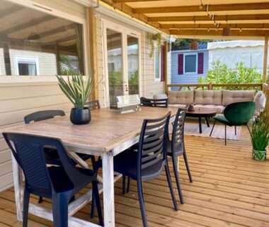 Terrasse couverte avec table et salon du camping Un toit sur le bassin les viviers