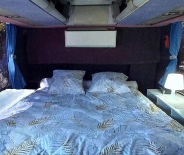 Intérieur du bus avec lit et lampes dans l'Unique et Insolite Bus Iliade