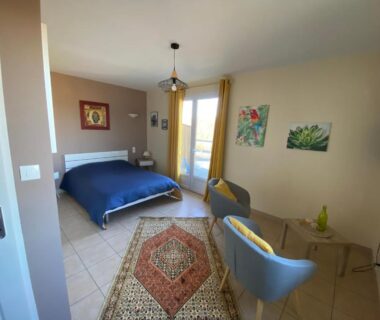 Chambre avec lit double et fauteuils donnant sur balcon du camping VAL ST GEORGES