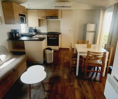 Séjour avec cuisine équipée canapé et table à manger dans le VM-Mobile Home 3 ch