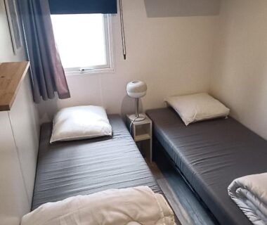 Chambre avec deux lits simples et fenêtre au camping Vacances dans les Landes