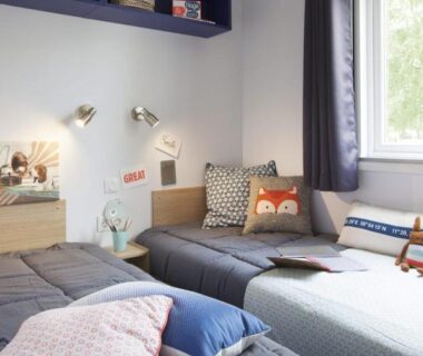 Chambre avec deux lits et coussins dans le mobil-home Camp’in Pirellu