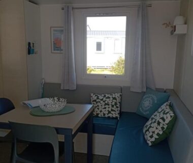 Intérieur avec banquette table et coussins dans le mobil-home Val Océan-bord de plage