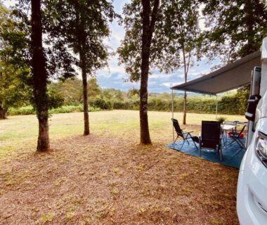 Emplacement ombragé avec camping-car et salon extérieur au Vanlodge