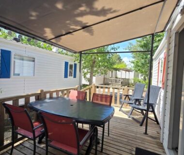 Terrasse couverte avec table et chaises au mobilhome du Camping Les Salisses